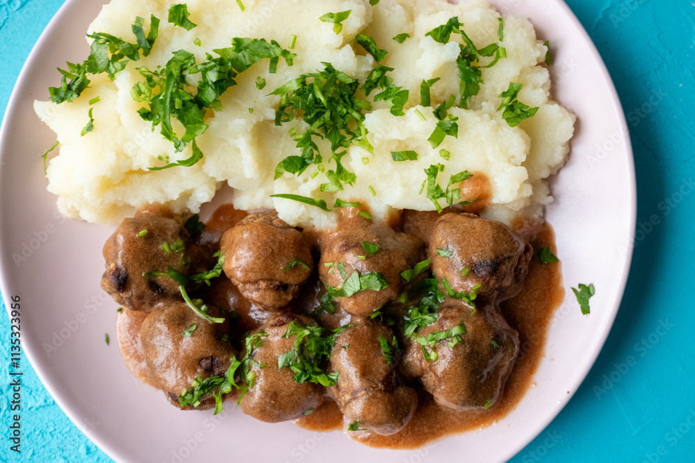 Swedish Meatballs with Gravy Sauce on a plate with mashed potatoes on a wooden background Swedish Meatballs with Gravy Sauce on a plate with mashed potatoes on a wooden background