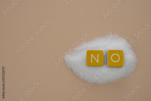 No sugar. Letters NO placed on a pile of white granulated sugar.