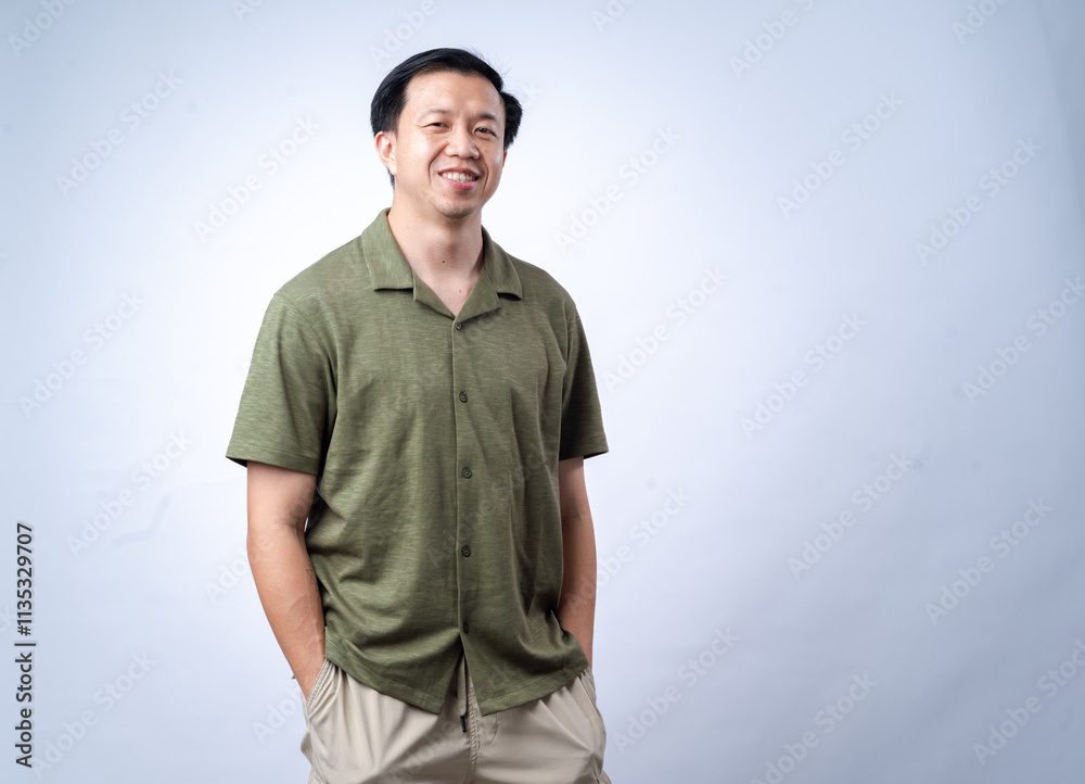 An Asian man wearing a green shirt stands confidently with his arms crossed, smiling warmly at the camera. The background is clean and white, emphasizing a professional and approachable demeanor An Asian man wearing a green shirt stands confidently with his arms crossed, smiling warmly at the camera. The background is clean and white, emphasizing a professional and approachable demeanor
