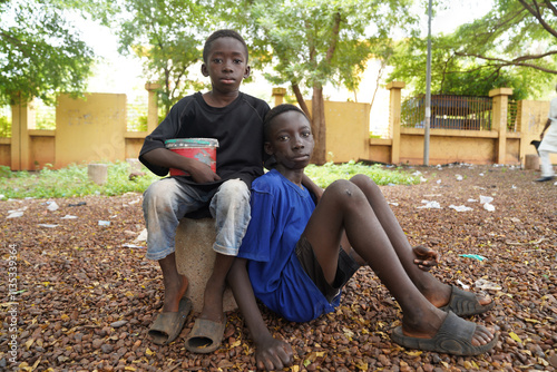 Two poor black African street children asking for alms - concept of child eploitation trough forced begging in African countries