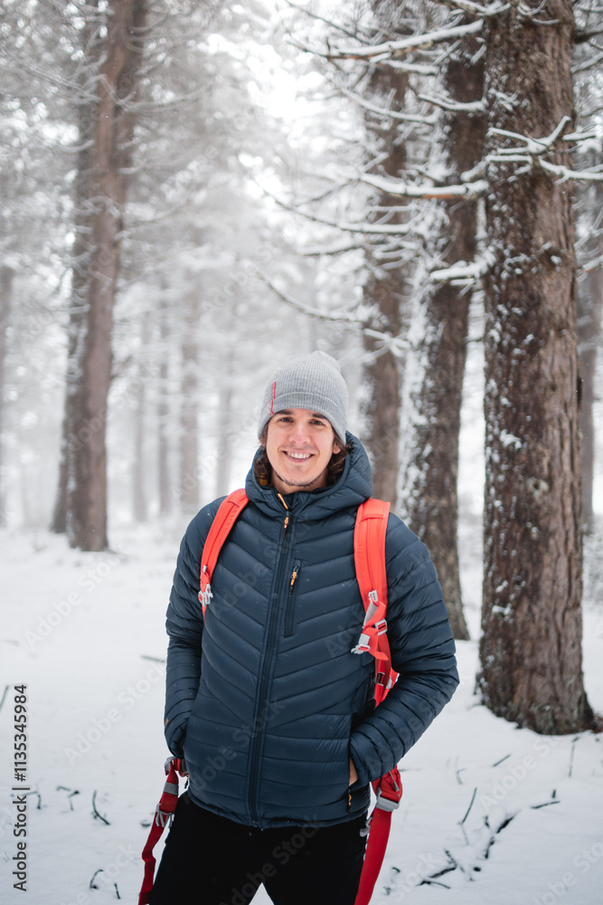 In Opacua, Álava, a young man in blue winter clothing enjoys in a snow-covered pine forest. In Opacua, Álava, a young man in blue winter clothing enjoys in a snow-covered pine forest.