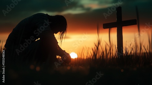 Silhouette of person praying at sunset cross.