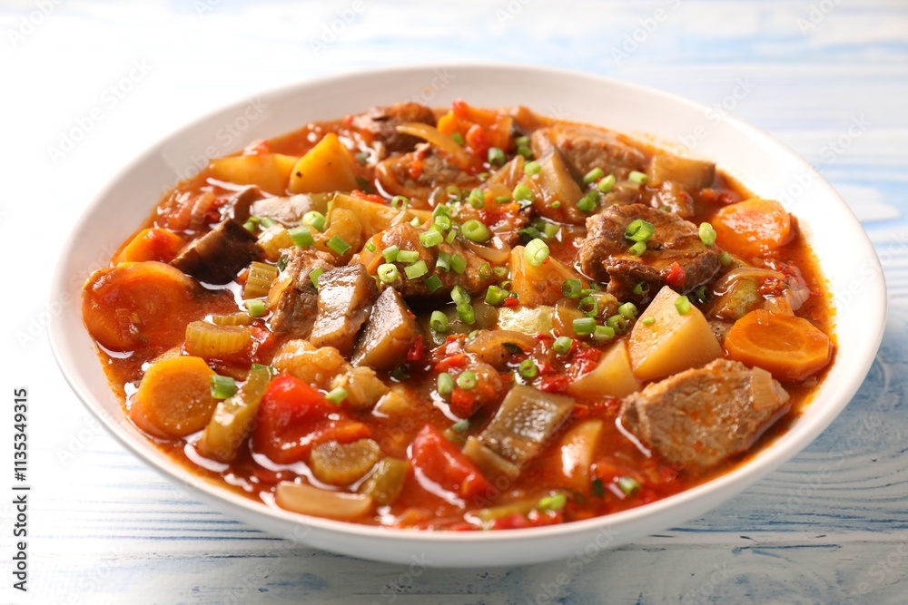 Delicious stew with vegetables in bowl on light blue wooden background, closeup Delicious stew with vegetables in bowl on light blue wooden background, closeup