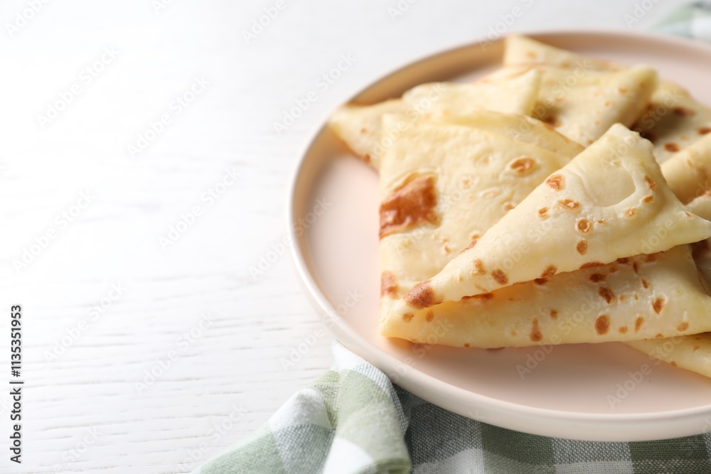 Delicious folded crepes on white wooden table, closeup. Space for text Delicious folded crepes on white wooden table, closeup. Space for text