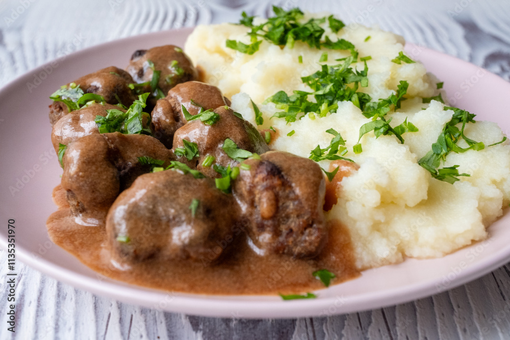 Swedish Meatballs with Gravy Sauce on a plate with mashed potatoes on a wooden background Swedish Meatballs with Gravy Sauce on a plate with mashed potatoes on a wooden background