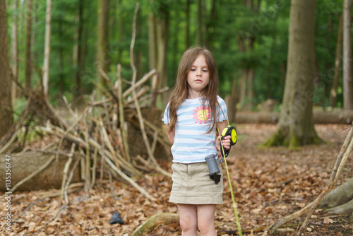 Little girl in hat walks in forest in summer. Concept of healthy child's games in open air