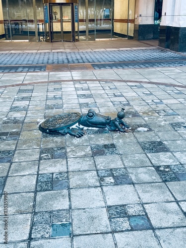 Piece of art in the streets in Brooklyn, where a crocodile is coming out of the sewer