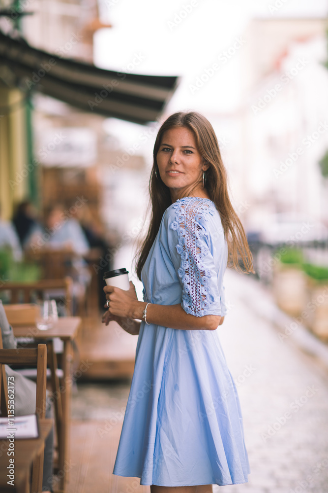 Obraz premium Caucasian attractive young woman walking out the door of a cafe.