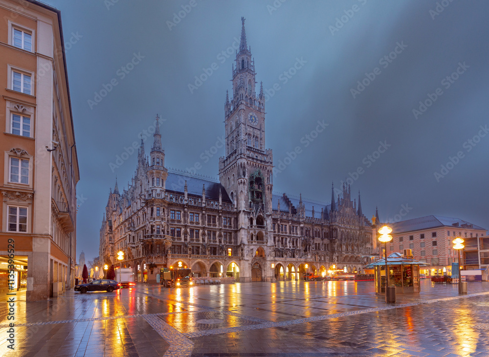 Fototapeta premium The illuminated New Town Hall at Marienplatz in Munich, Germany, during a rainy evening.