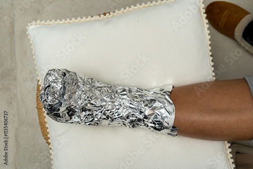 Foot Wrapped in Aluminum Foil Resting on a Pillow