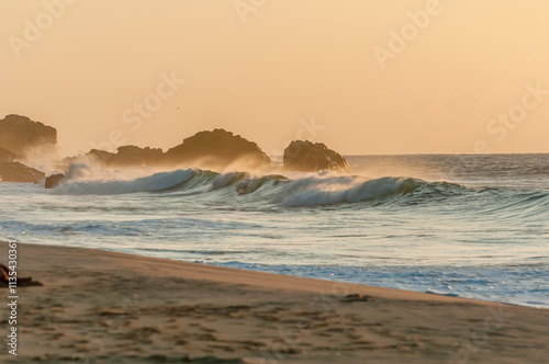 Twilight presents the gentle breeze of the strong wind, while the waves of the sea reflect the golden glow of the sun. The sand is touched by the spray of the water, on the beautiful beaches of Noronh