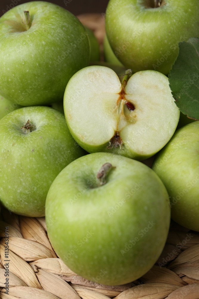 Whole and cut green apples on wicker mat, closeup Whole and cut green apples on wicker mat, closeup