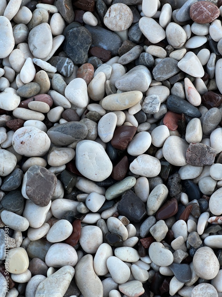 Pebble sea beach close-up. Smooth round pebbles texture background. Gray and white sea stones. Pebble sea beach close-up. Smooth round pebbles texture background. Gray and white sea stones.