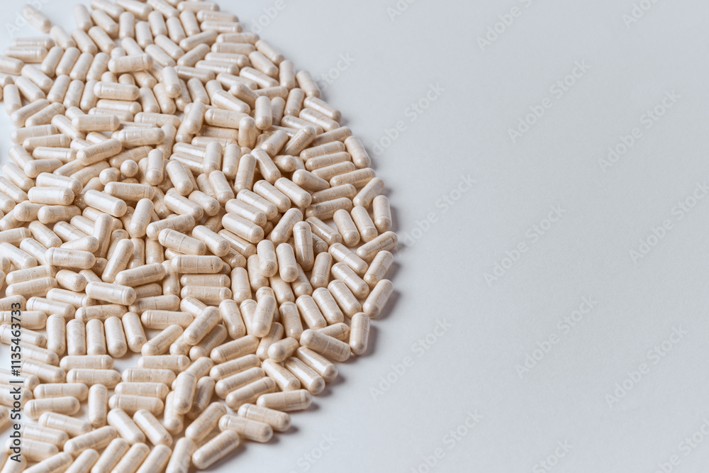 Clear capsules filled with beige powder spilled on table round shape pharmaceutical background Clear capsules filled with beige powder spilled on table round shape pharmaceutical background