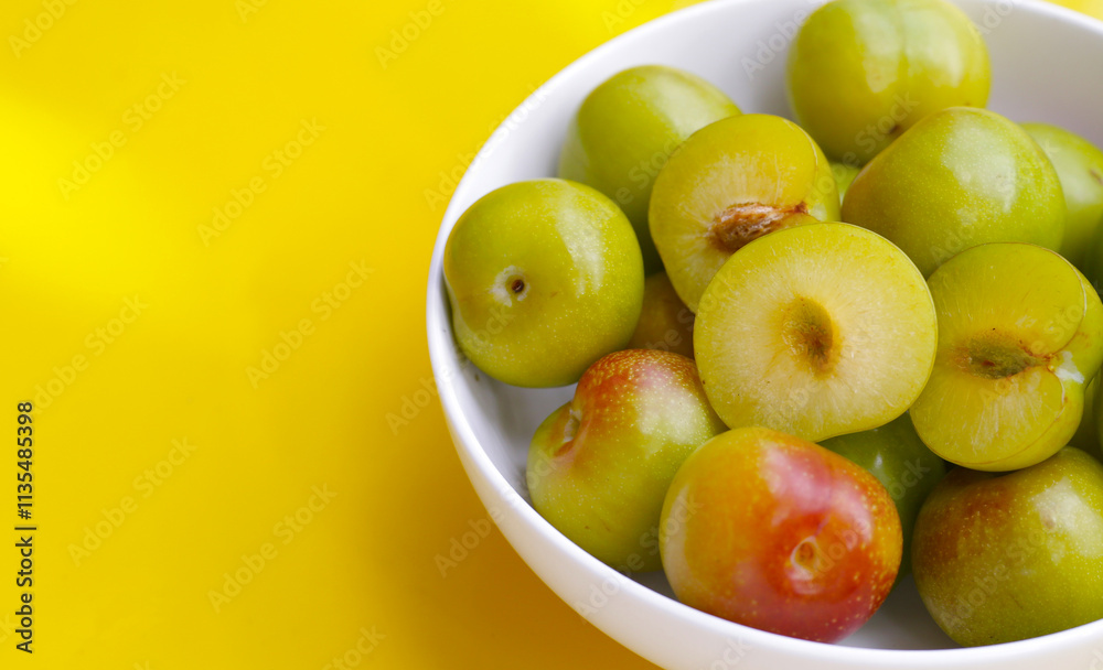 Fresh green plum fruit on yellow background. Fresh green plum fruit on yellow background.