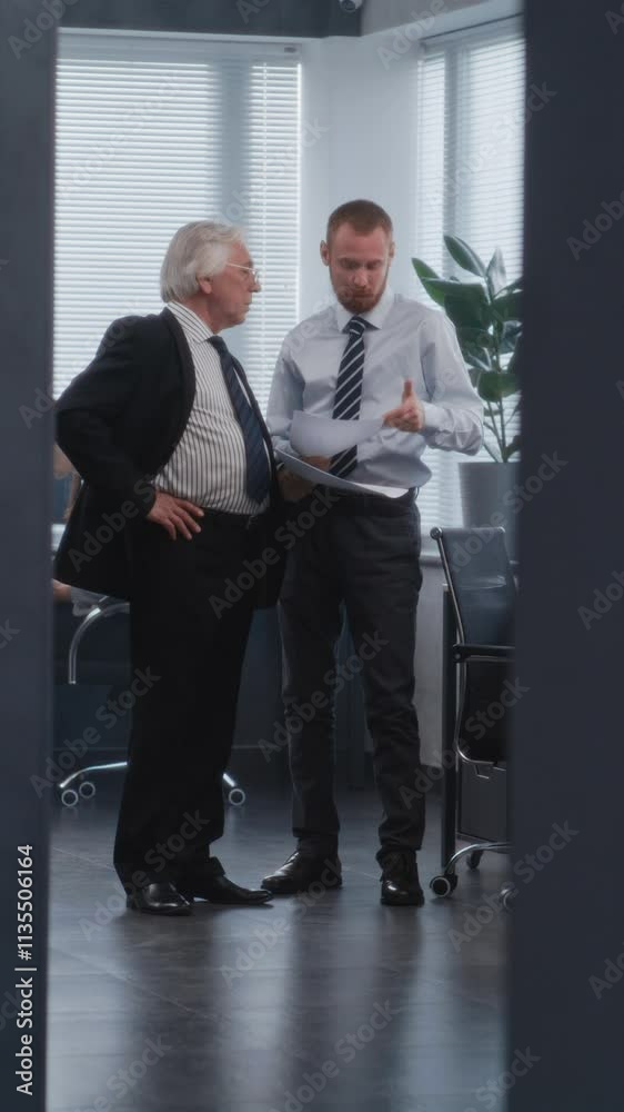 Team leader of department's managers discussing business strategy of company with boss, analyzing papers and documents. Female manager enters meeting room. Business and entrepreneurship concept. Team leader of department's managers discussing business strategy of company with boss, analyzing papers and documents. Female manager enters meeting room. Business and entrepreneurship concept.