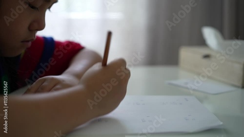 mathematics by closeup hand asian child doing homework or kid girl student writing quick math calculation in paper by pencil for studying in classroom or learn from home and learning calculate numbers