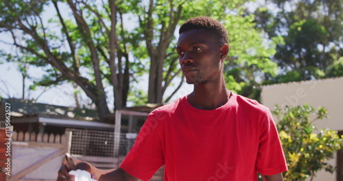 Volunteer in red shirt caring for dogs at outdoor animal shelter photo