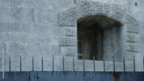 Massive iron gates with sharp spikes on top at an abandoned military base. Iconic Fort Bourguignon (Fort Monsival) built by the Austrian Empire. Old metal structures. Pula, Croatia - December 1, 2024