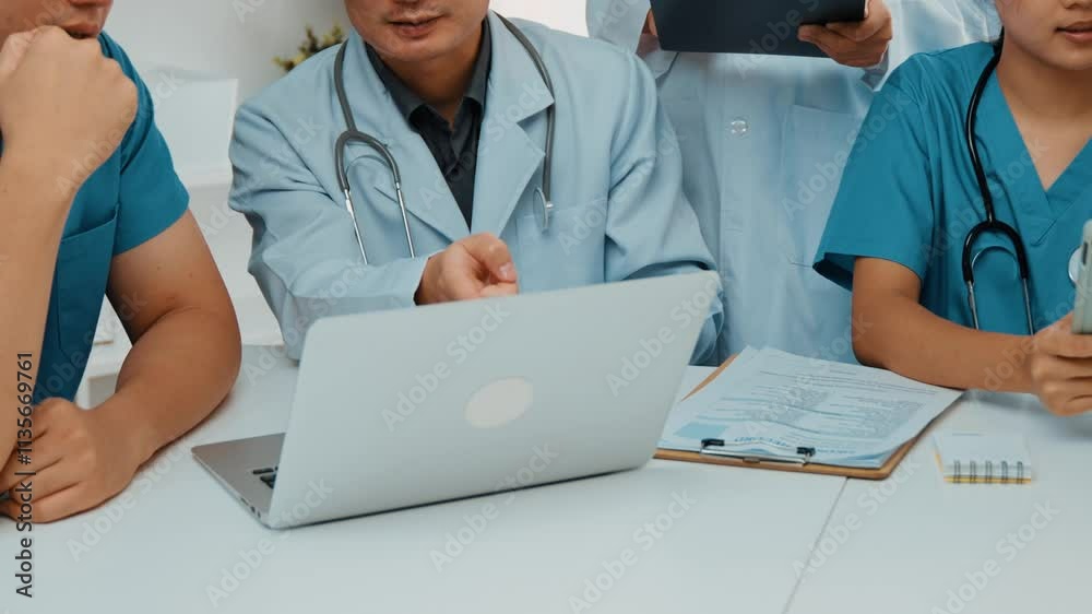 Professional group of medical working and planning medical treatment or healthcare system at hospital table together. Teamwork lead to successful illness and sickness treatment. Slow motion. Rigid. Professional group of medical working and planning medical treatment or healthcare system at hospital table together. Teamwork lead to successful illness and sickness treatment. Slow motion. Rigid.