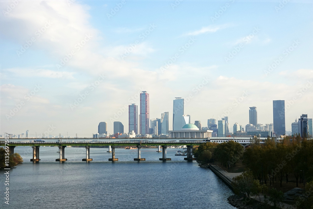 Naklejka premium A skyline of Yeouido, Seoul, Korea with modern skyscrapers and a bridge over a river.