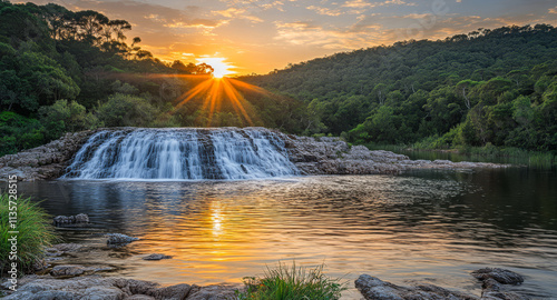 Fototapeta Naklejka Na Ścianę i Meble -  Sunset view over a tranquil waterfall in a lush green forest