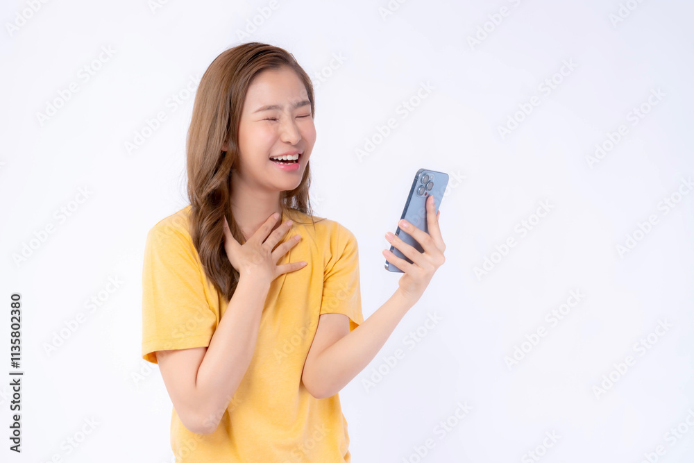 Cheerful and Beautiful Asian Young Woman in Yellow T-Shirt Laughing While Looking at Smartphone, Expressing Happiness and Excitement, Isolated on White Background, Concept of Digital Communication Cheerful and Beautiful Asian Young Woman in Yellow T-Shirt Laughing While Looking at Smartphone, Expressing Happiness and Excitement, Isolated on White Background, Concept of Digital Communication