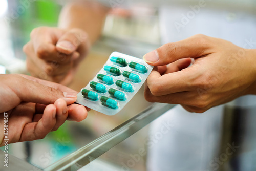 Fotografía Image of a pharmacist dispensing antibiotic medication to a patient at a pharmacy counter, Thailand