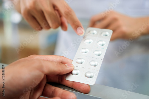 Quadro su tela Image of a pharmacist advising a patient on the dosage of antihistamines at a pharmacy counter, Thailand