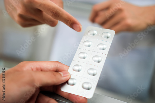 Image of a pharmacist advising a patient on the dosage of antihistamines at a pharmacy counter, Thailand.