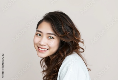 Half-length portrait of a smiling Asian female with calm happiness