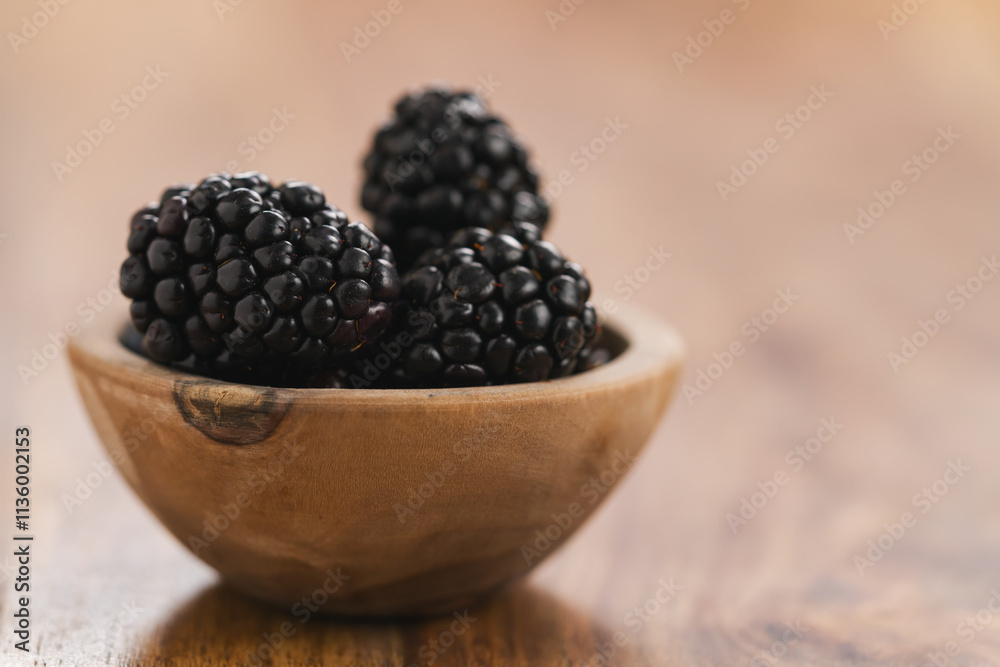 fresh blackberries in wood bowl on wooden table fresh blackberries in wood bowl on wooden table