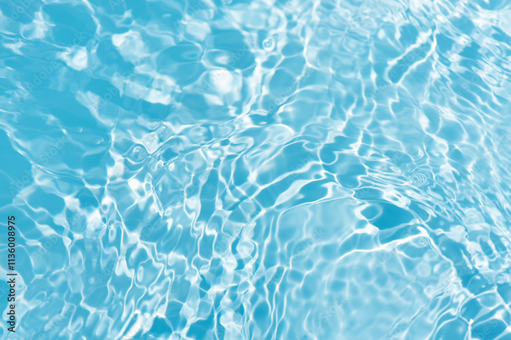 Obraz premium Blue water with ripples on the surface. Defocus blurred transparent blue colored clear calm water surface texture with splashes and bubbles. Water waves with shining pattern texture background.