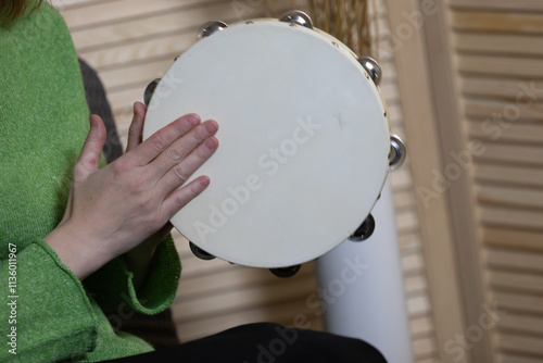 Close up of woman hand playing classical professional tambourine at home. Ethnic folk rhythm, hippie trance entertainment of shaman, professional artist rehearsing performance