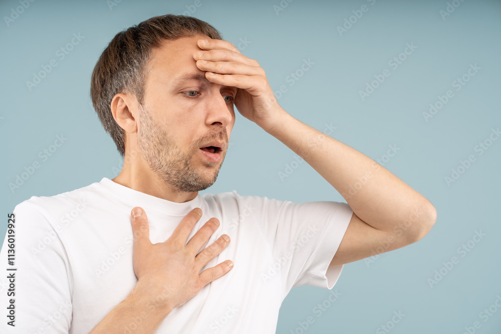 Stressed man with panic attack holding head, chest in distress tries to regain control. Anxious male with difficult breathing, rapid heartbeat feels emotional distress, chronic fear, phobias, burnout. Stressed man with panic attack holding head, chest in distress tries to regain control. Anxious male with difficult breathing, rapid heartbeat feels emotional distress, chronic fear, phobias, burnout.