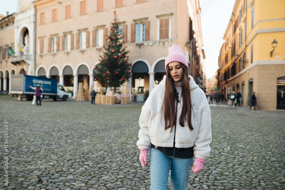 Obraz premium A Young Woman Dressed in a Cozy Winter Outfit Walks on a Charming Cobblestone Street