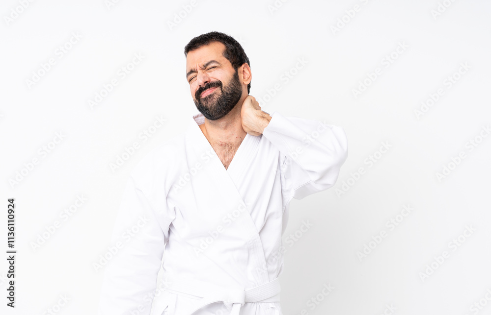 Young man doing karate over isolated white background with neckache Young man doing karate over isolated white background with neckache