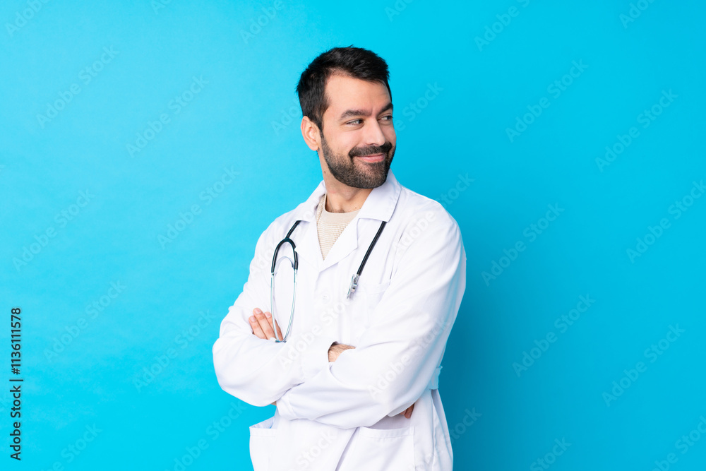 Young caucasian man over isolated background wearing a doctor gown and with arms crossed Young caucasian man over isolated background wearing a doctor gown and with arms crossed
