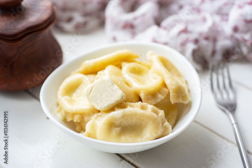 Dumplings with cottage cheese for breakfast in a white plate on a white table. Delicious vegetarian dumplings for dessert. Close-up photo