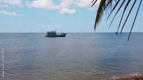 A Vietnamese fishing boat comes ashore and drops anchor