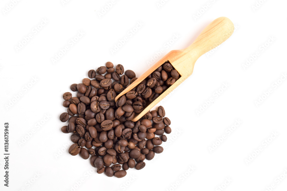 Obraz premium Roasted coffee beans in wooden spoon isolated on white background. Top view