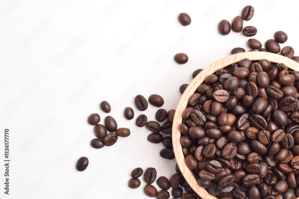 Obraz premium Roasted coffee bean in wooden bowl isolated on white background. Top view. Flat lay. Space for text