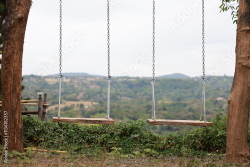 A pair of swings with a mountain behind them