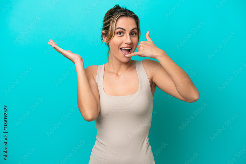Young caucasian woman isolated on blue background making phone gesture and doubting Young caucasian woman isolated on blue background making phone gesture and doubting