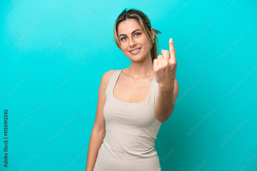 Young caucasian woman isolated on blue background doing coming gesture Young caucasian woman isolated on blue background doing coming gesture