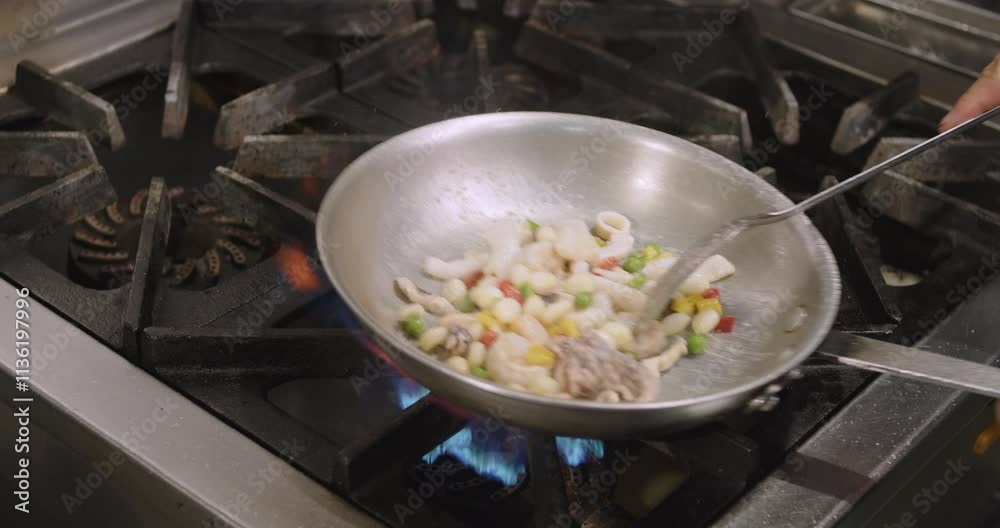 slow-motion of the chef flipping the ingredient of Peruvian Seafood Rice in the pot on the stove slow-motion of the chef flipping the ingredient of Peruvian Seafood Rice in the pot on the stove