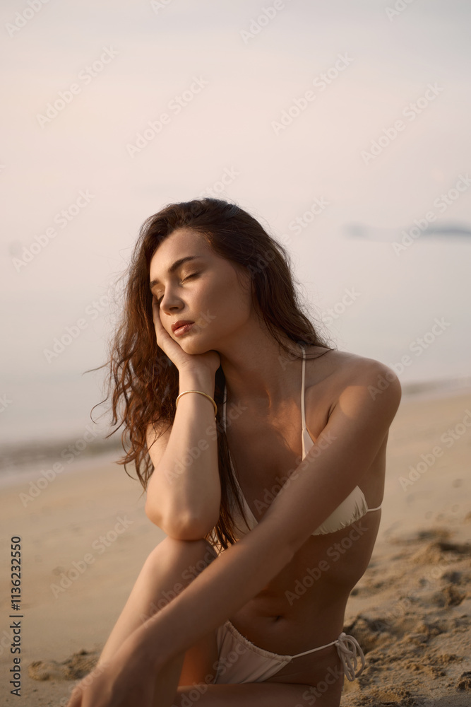 Sitting Beautiful model in sand on the beach. Sexy girl in Bikini Sitting Beautiful model in sand on the beach. Sexy girl in Bikini