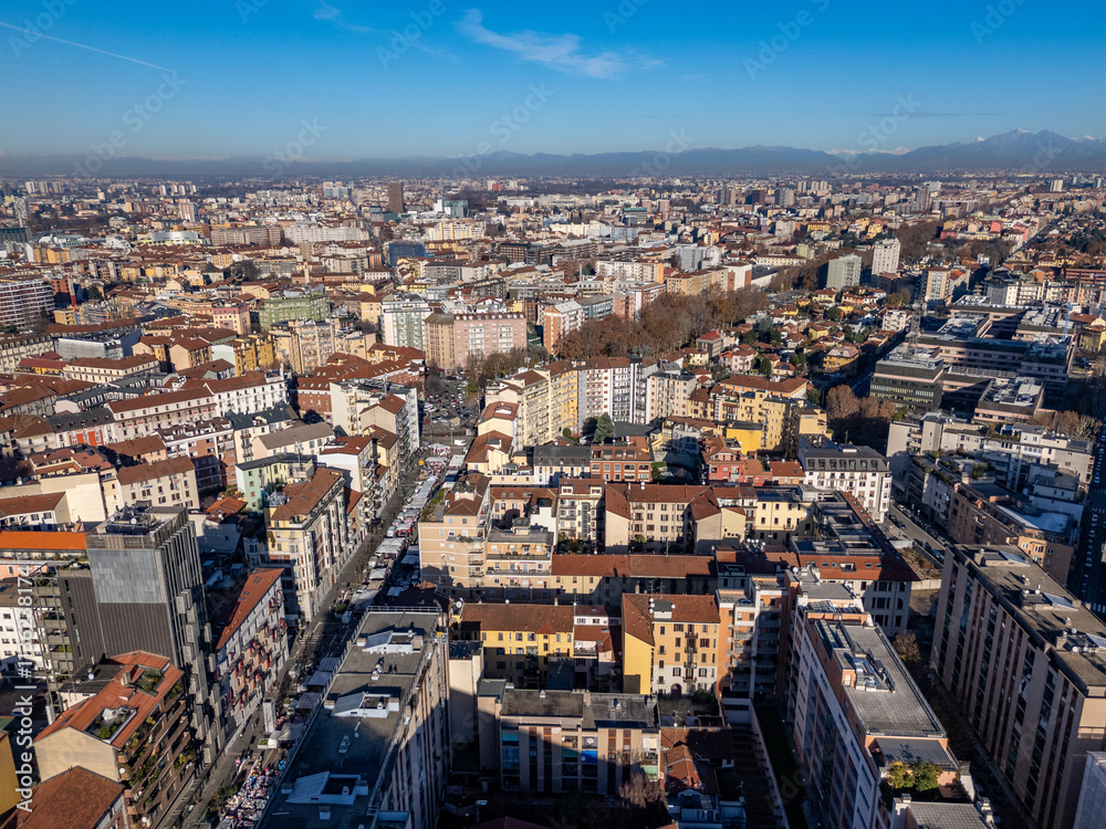 Aerial view of Milan showcasing urban landscape with diverse architecture under a clear blue sky. Italy Aerial view of Milan showcasing urban landscape with diverse architecture under a clear blue sky. Italy