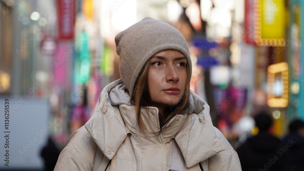 Pretty woman smiling in a knitted hat on a background of the city. Pretty woman smiling in a knitted hat on a background of the city.