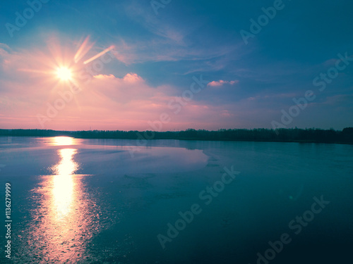 Aerial view of the frozen lake in the evening at sunset light. Beautiful nature landscape